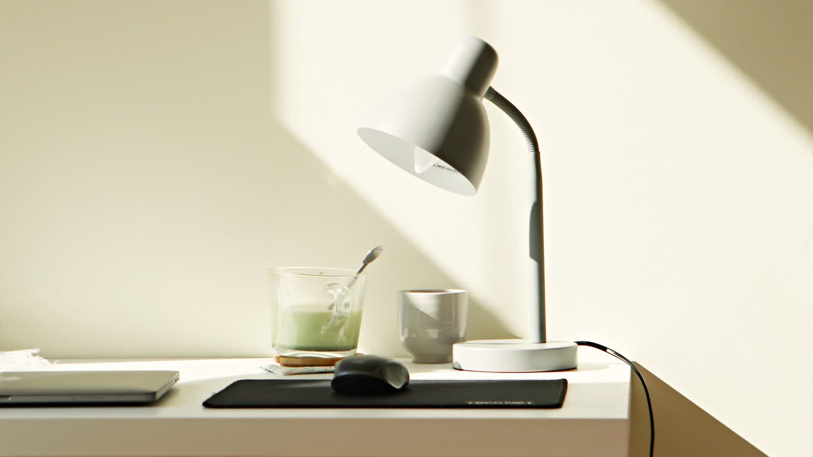 A slim desk lamp on a white desk
