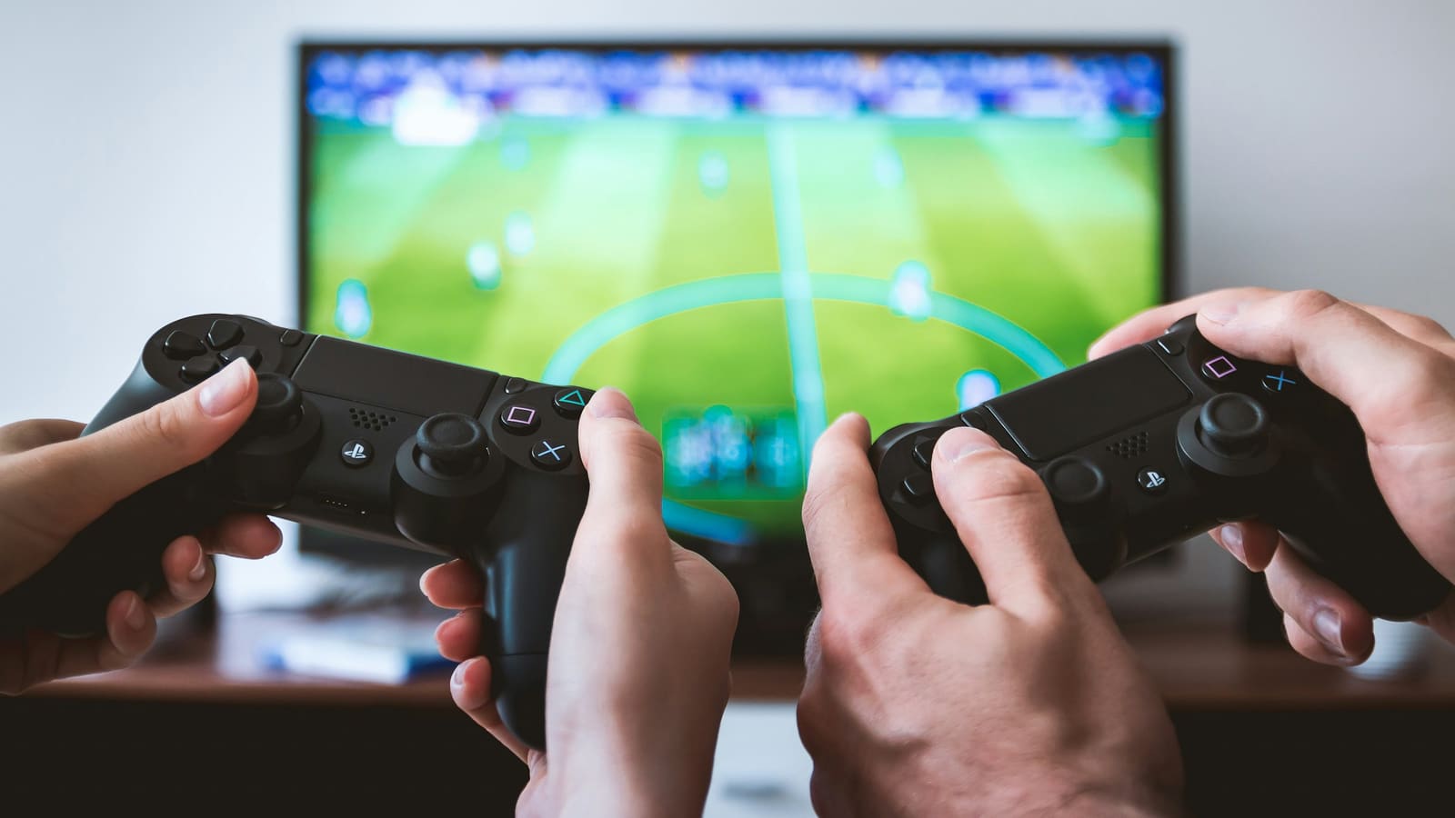 Two people holding game controllers in front of a television