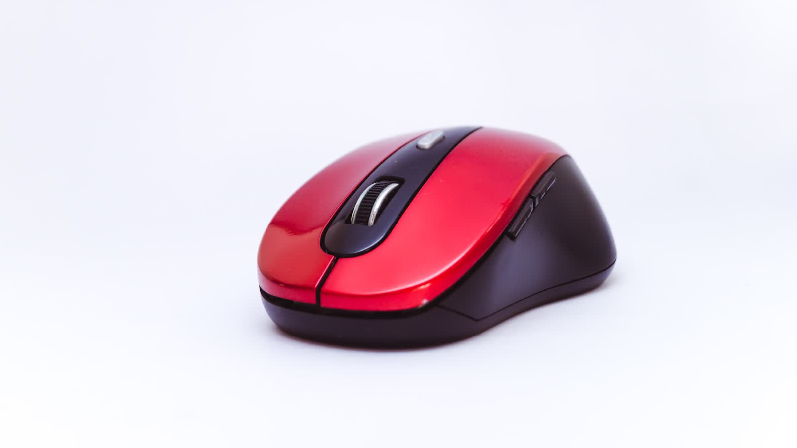 A red wireless mouse on a plain white background