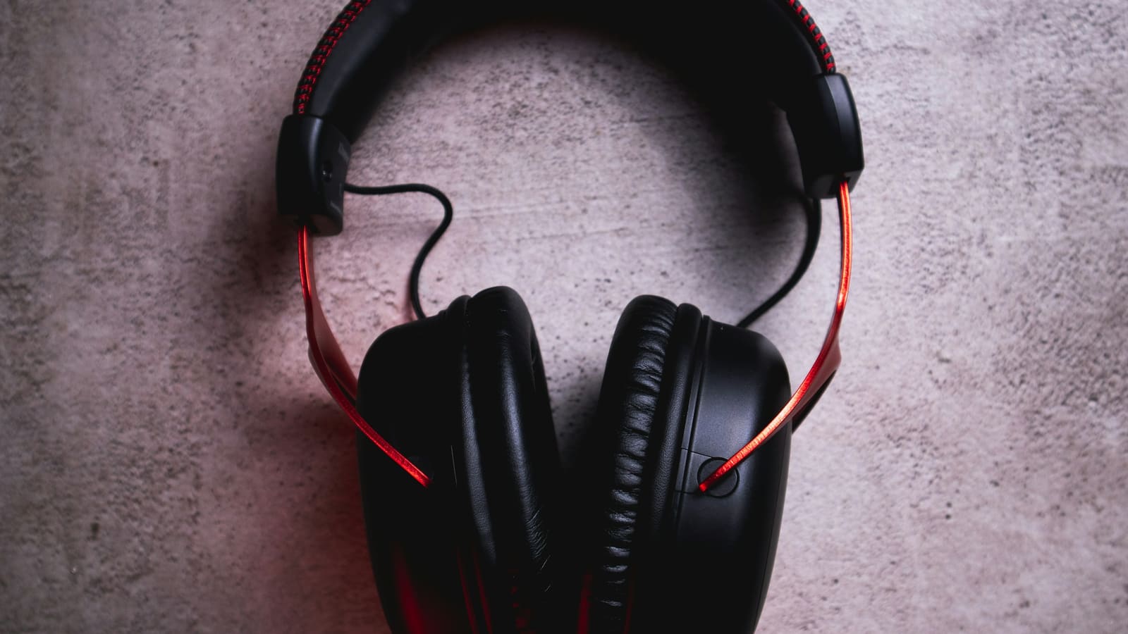 Over-ear headphones resting on a concrete surface