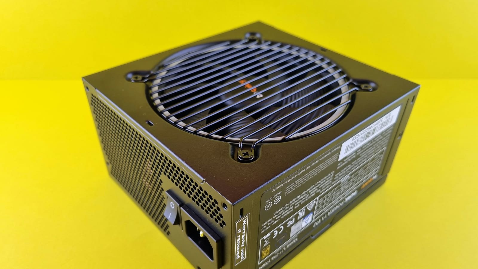 A computer power supply photographed from above, showing its fan grille