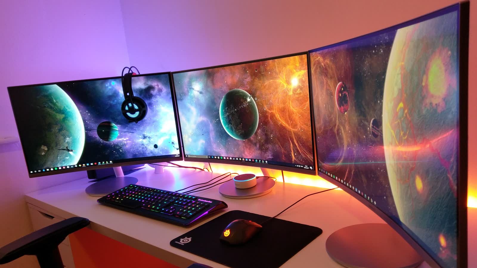 A desk with several wide curved monitors side by side