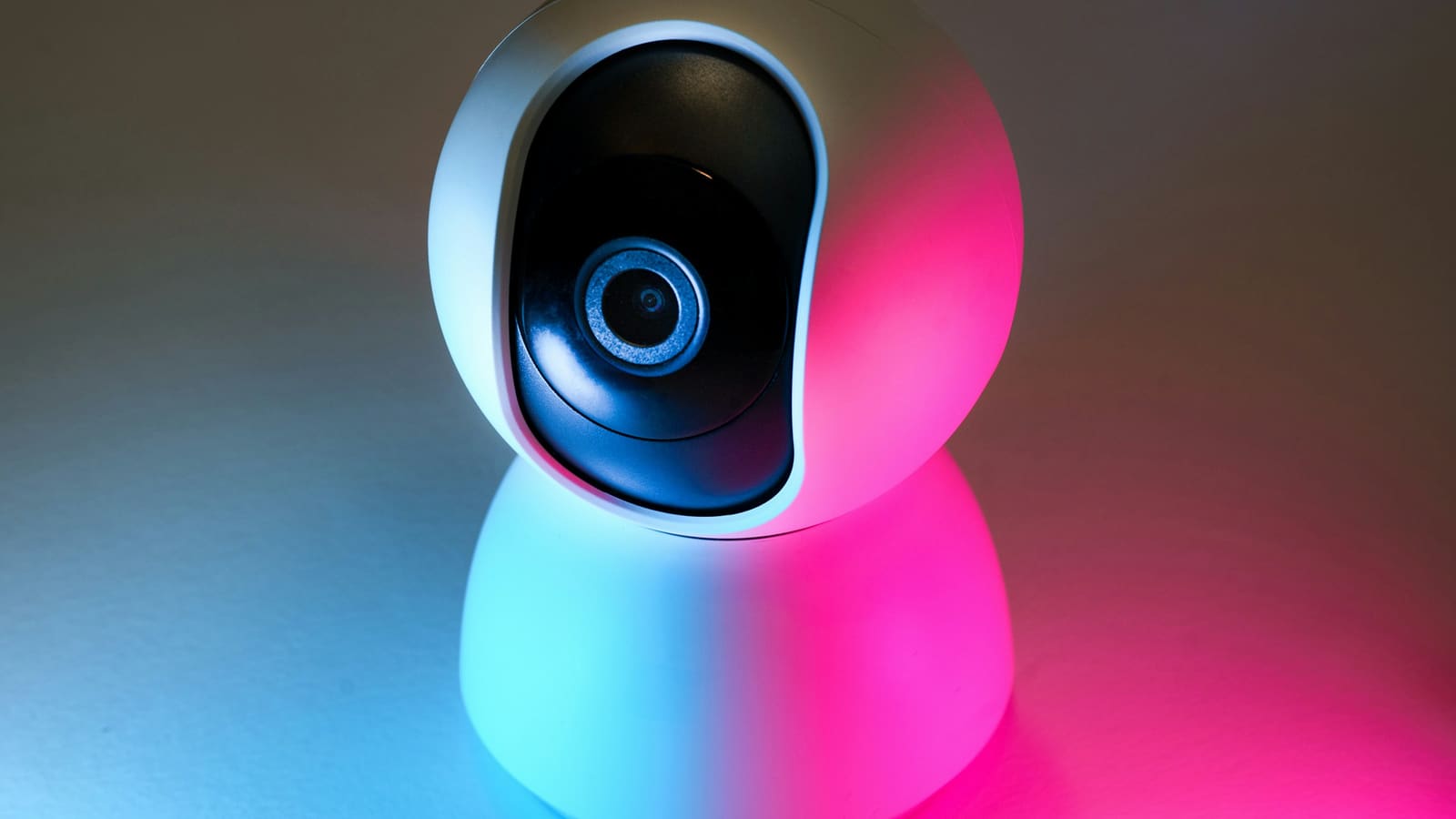 A small pan-and-tilt camera lit with coloured light