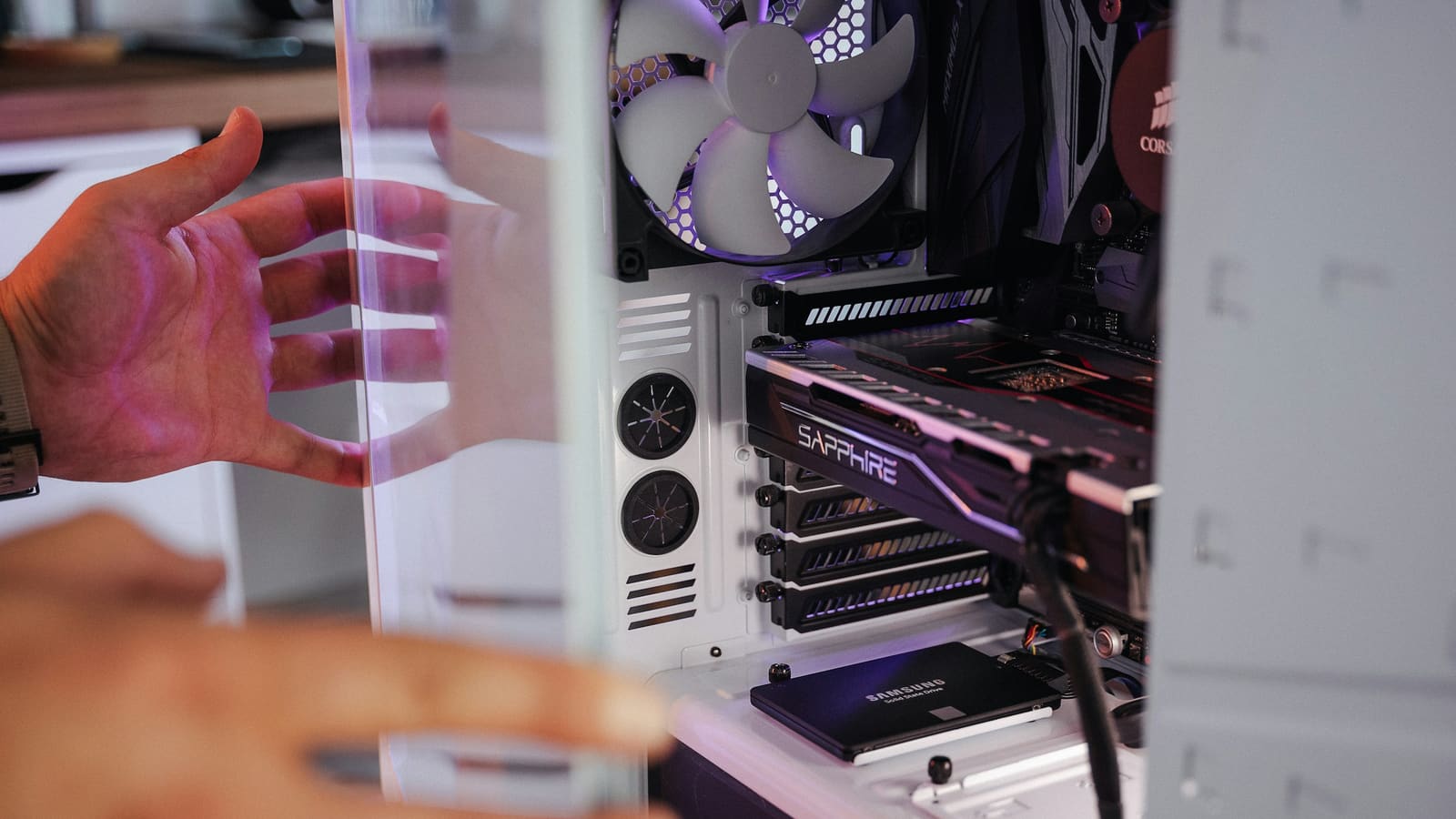 Hands guiding a graphics card into place inside a computer case