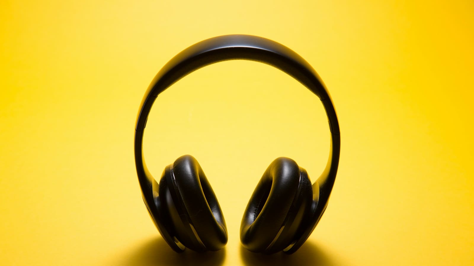 Over-ear headphones photographed against a yellow background