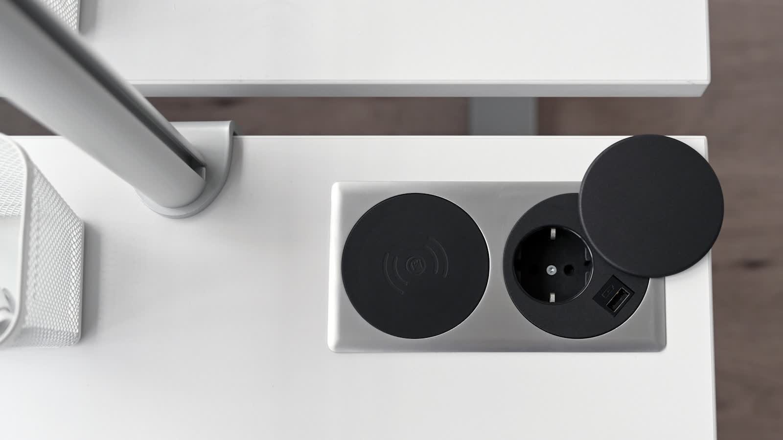 A power socket set into a cut-out in a desk surface