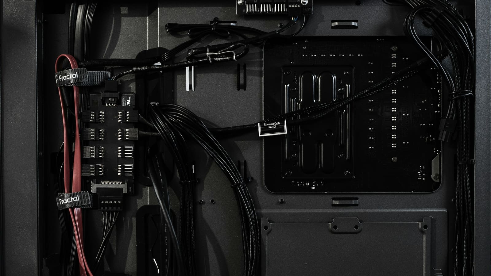 The lower compartment of a computer case with power cables routed through it