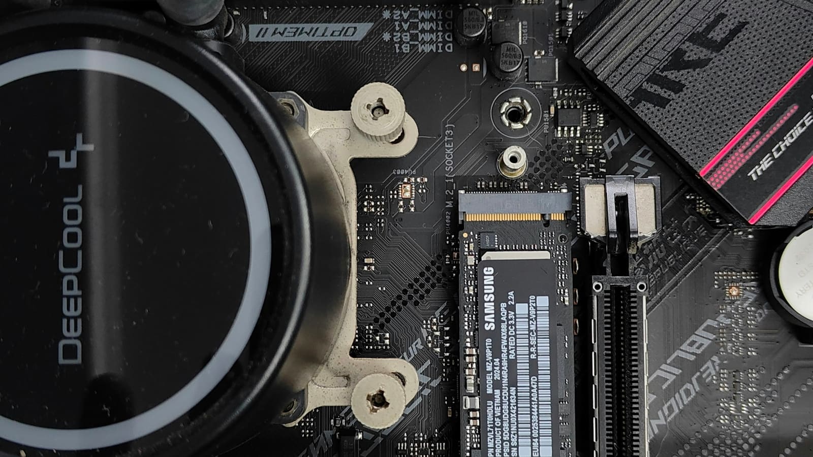 A motherboard with an empty drive slot beside a processor cooler