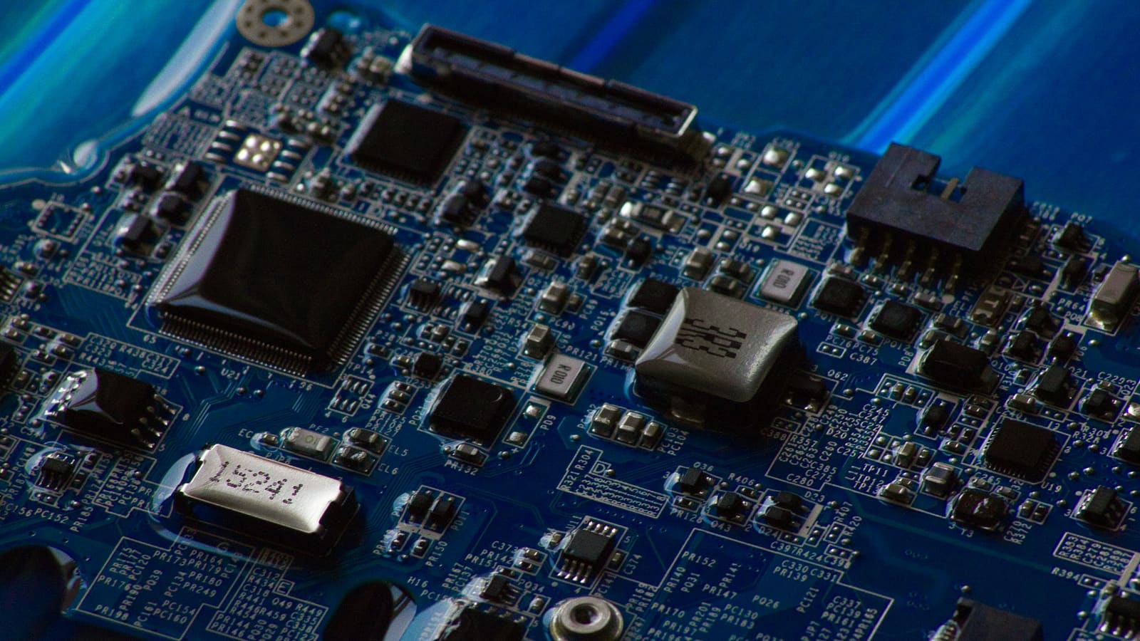 Close-up of a circuit board with its chips and traces in focus