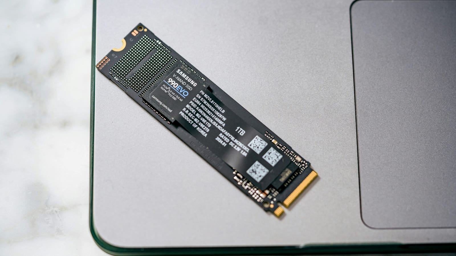 An M.2 solid-state drive resting on a grey surface