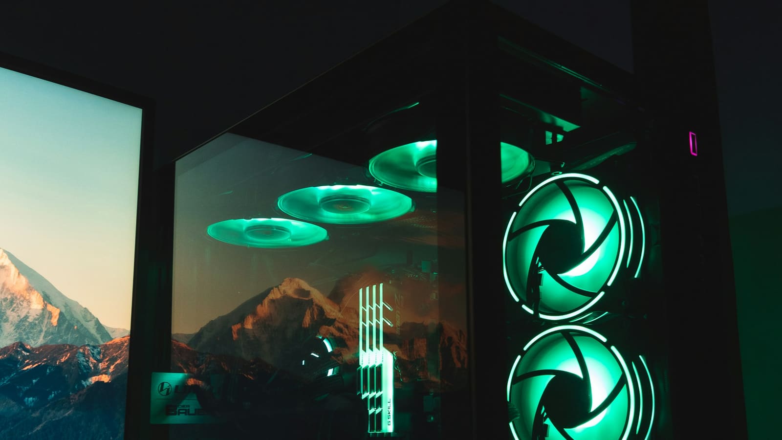 A computer case seen through its side panel with three fans running