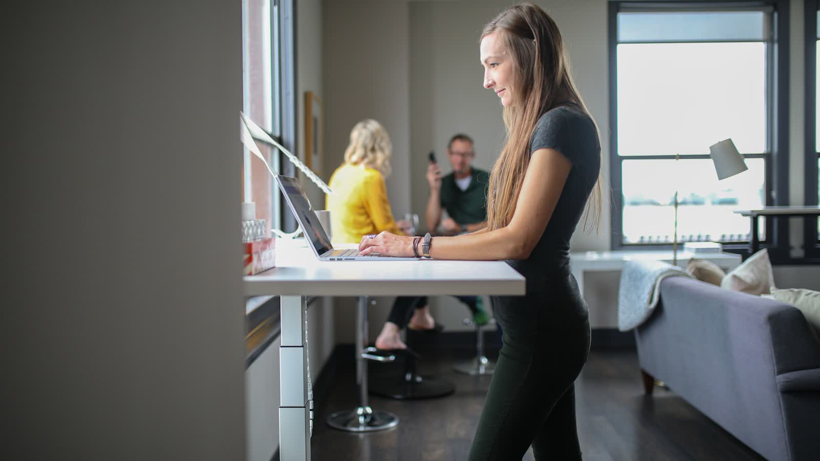 Two people working, one seated and one at a standing desk